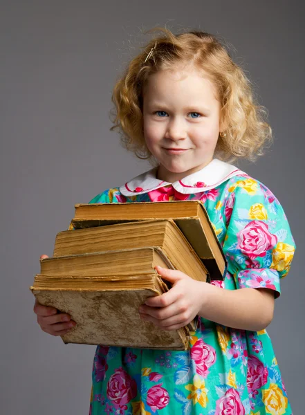Preschool girl carrying books — Stock Photo, Image