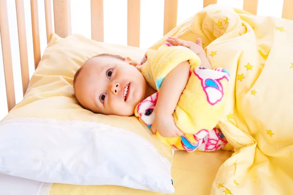 Smiling baby in crib — Stock Photo, Image