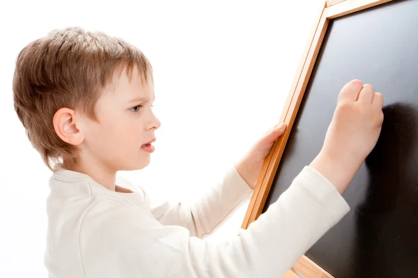 Boy writing on blackboard — Stock Photo, Image