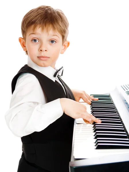 Gutt som spiller piano – stockfoto
