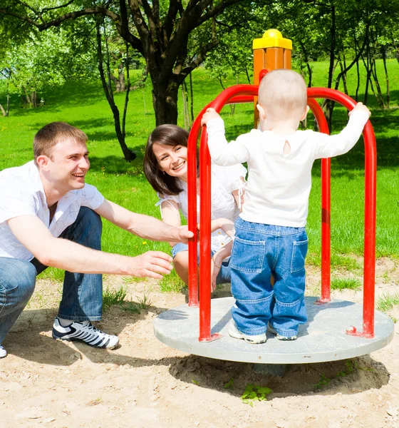 Föräldrar roterande merrygoround — Stockfoto