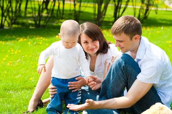 Familjen sitter på gräset — Stockfoto
