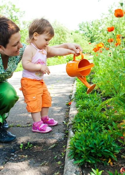 Mother and daughter watering plants — Stock Photo, Image