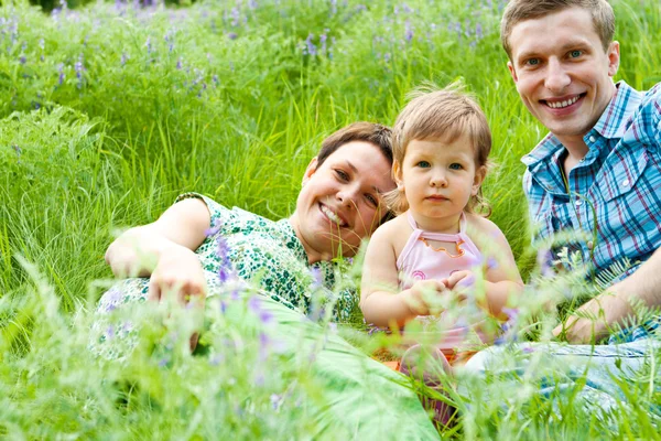 Родители и их дочь в траве — стоковое фото