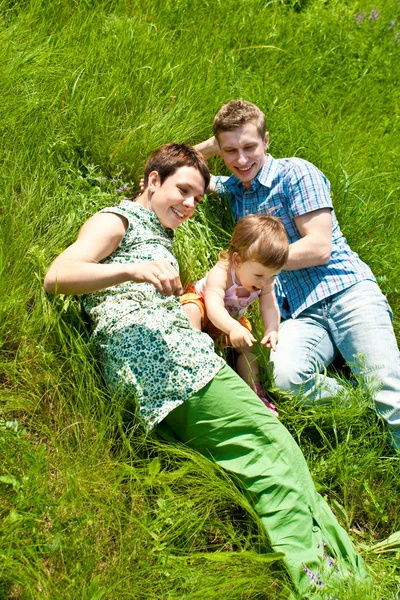 Семья лежит в траве — стоковое фото