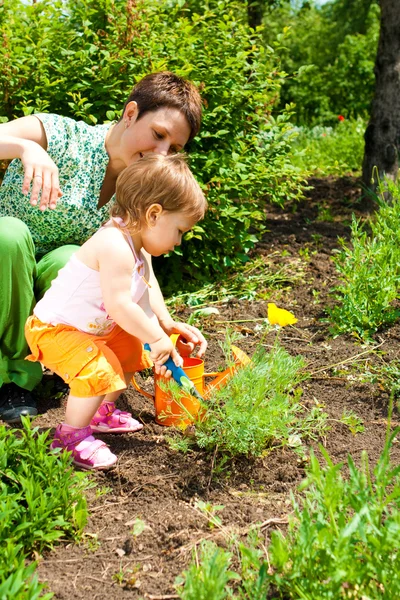 Pomoc matki w ogrodzie — Zdjęcie stockowe