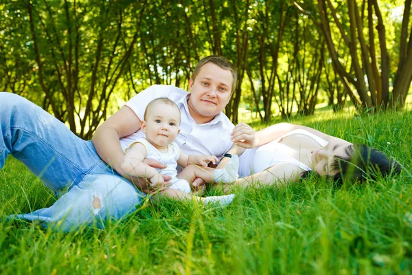 Mamma, pappa och baby i park — Stockfoto