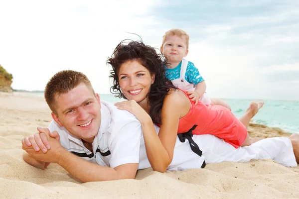 Familjen liggande på sand — Stockfoto
