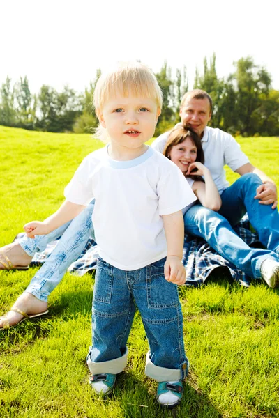 Тоддлер и родители на траве — стоковое фото