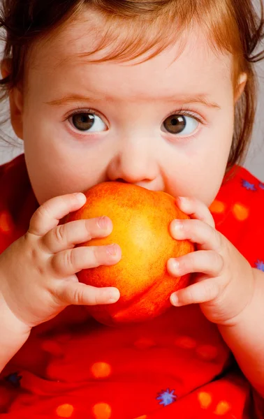 Baby eating peach — Stock Photo, Image