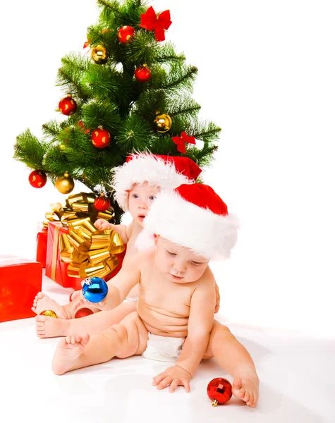 Bébés à côté de l'arbre de Noël Photos De Stock Libres De Droits