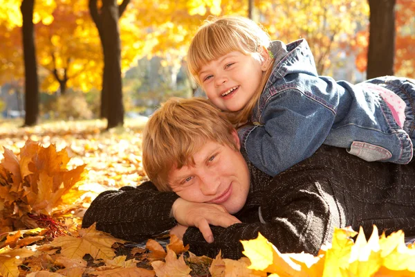 Daddy and doughter on autumn leaves — Stock Photo, Image