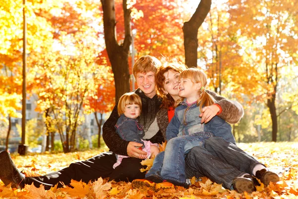 Семья на осенних листьях — стоковое фото