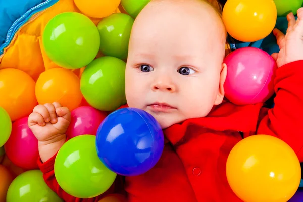 Spädbarn med färgglada bollar — Stockfoto