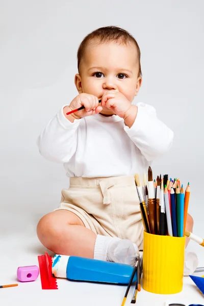 Kid playing with paints and pencils — Stock Photo, Image