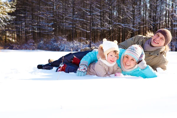Родители и их дочь лежат в снегу — стоковое фото