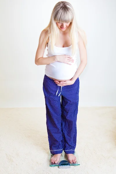 Těhotná žena na váze — Stock fotografie