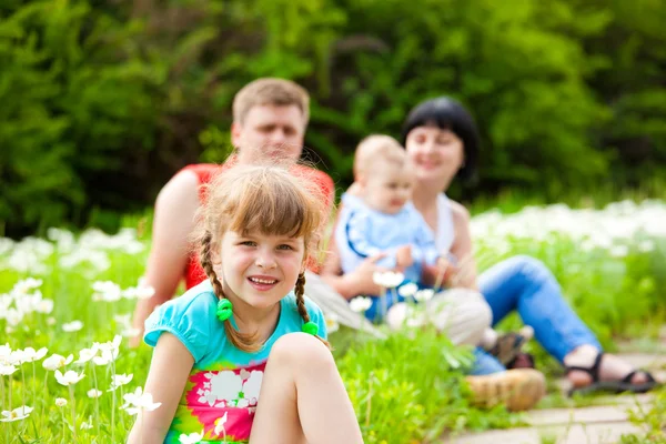Girl in the meadow and her family — Stock Photo, Image