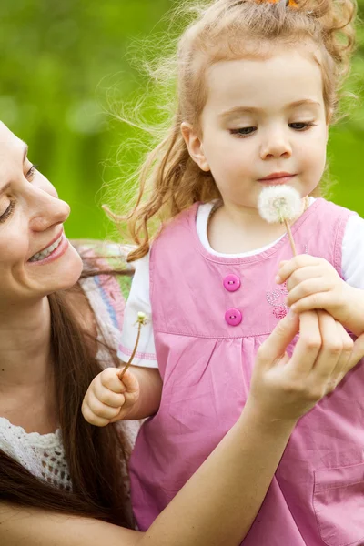 Mom giving dandelion to daughter — Stock Photo, Image