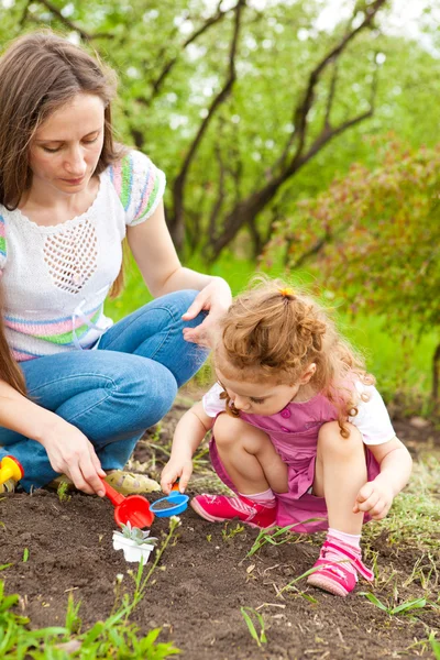 Dotter att hjälpa mamma i trädgården — Stockfoto