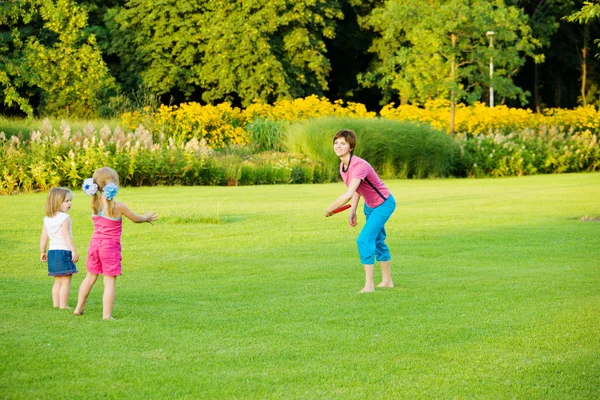 Mother throwing frisbee — Stock Photo, Image