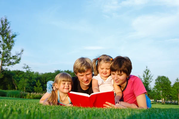 Parents reading to daughters — Stock Photo, Image