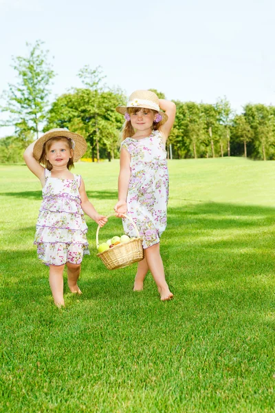 Little girls carrying fruit basket — Stock Photo, Image