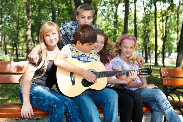 Подростки в парке играют на гитаре — стоковое фото