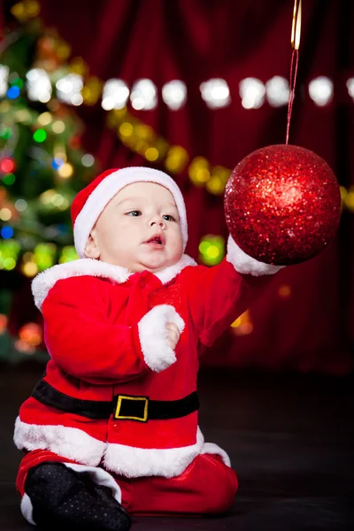 Baby playing with Christmas ball — Stockfoto