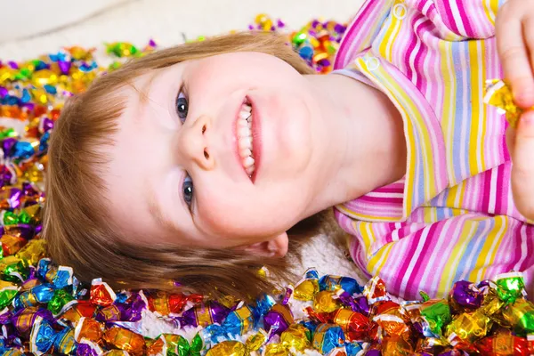 Дитина лежить серед цукерок — стокове фото