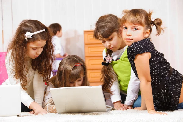 Crianças sentam-se em torno laptop — Fotografia de Stock
