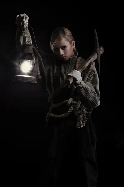 Mulher segurando picareta e lâmpada de óleo — Fotografia de Stock