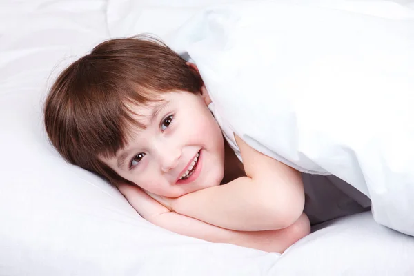 Chico alegre en la cama — Foto de Stock
