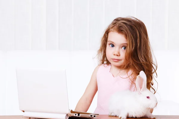 Дівчинка з ноутбуком і кроликом — стокове фото
