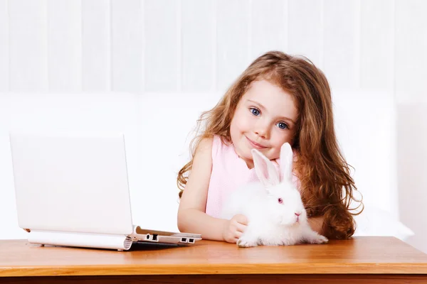 Mädchen mit weißem Kaninchen und Laptop — Stockfoto