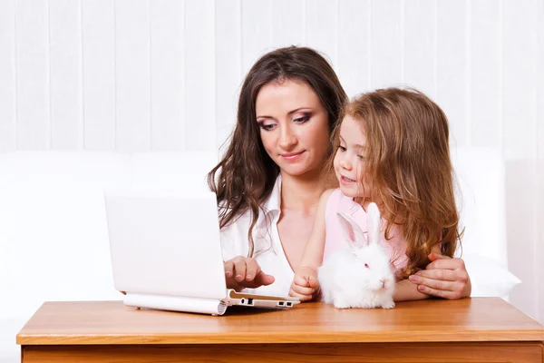 Kind, moeder, konijnen en laptop — Stockfoto