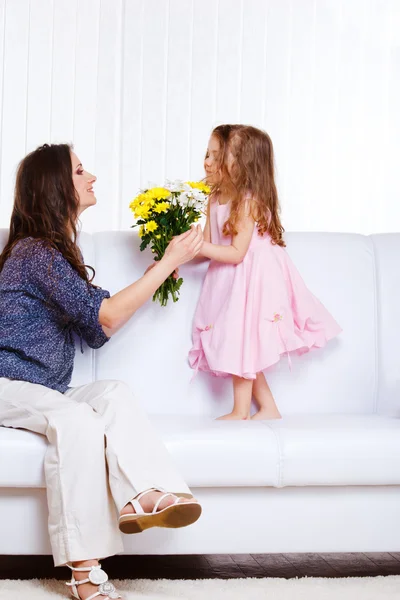 Kid presenting flowers to mother — Stock Photo, Image