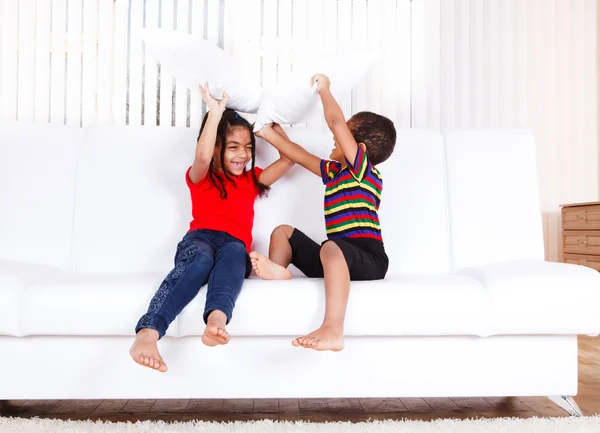 Crianças brincando com travesseiros — Fotografia de Stock
