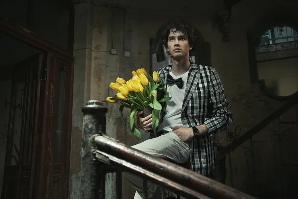 Homem na moda jovem que mantém ramo de flores — Fotografia de Stock