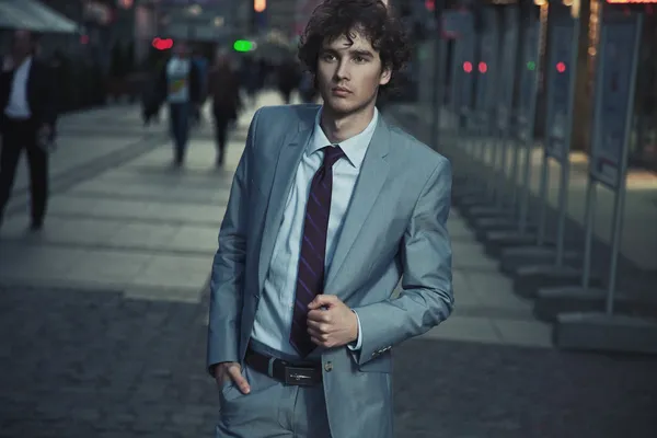 Handsome guy walking on a evening city street — Stock Photo, Image