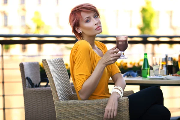Vacker rödhårig kvinna dricker kaffe på solig dag — Stockfoto