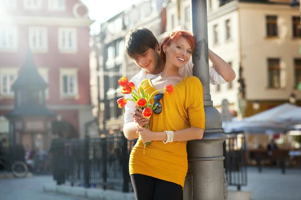 Casal jovem com flores, ao ar livre — Fotografia de Stock