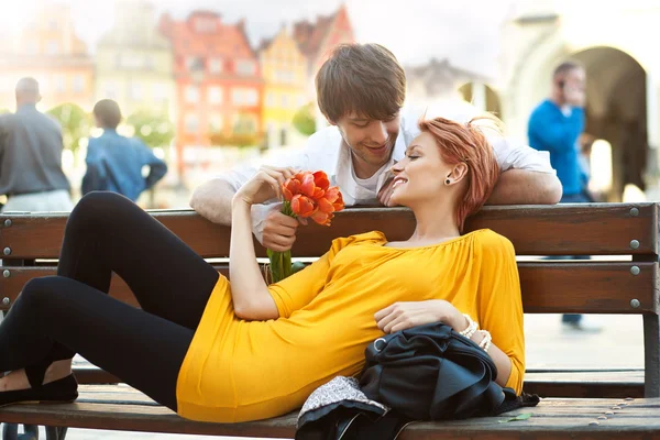 Romântico jovem casal relaxante ao ar livre sorrindo — Fotografia de Stock