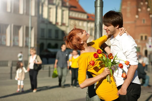 Жінка тримає квітковий букет посміхається чоловікові . — стокове фото