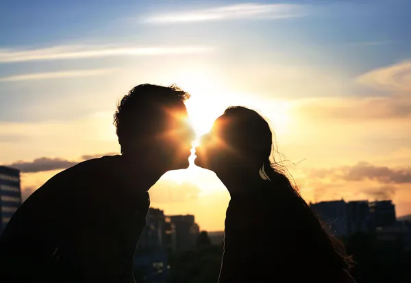 Şehrin arka plan akşam üzerinde çift öpüşme — Stok fotoğraf