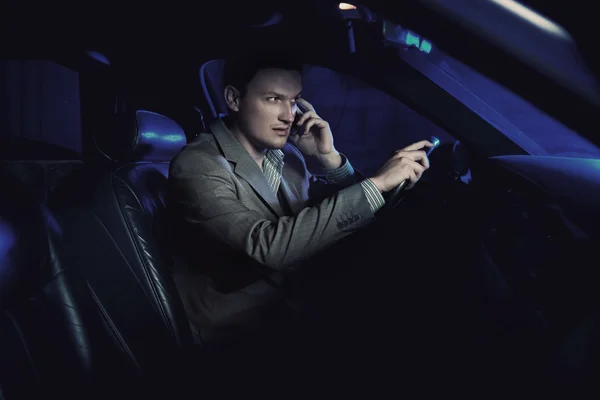 Элегантный мужчина за рулем и разговаривает по телефону — стоковое фото