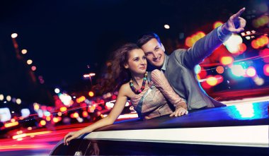 Elegant couple traveling a limousine at night