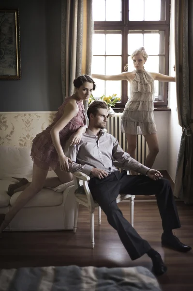 Jóvenes modelos masculinos y femeninos posando en un interior elegante — Foto de Stock