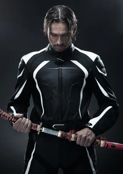 Bonito homem segurando uma espada samurai — Fotografia de Stock