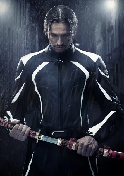Homem musculoso segurando espada samurai em uma noite chuvosa — Fotografia de Stock